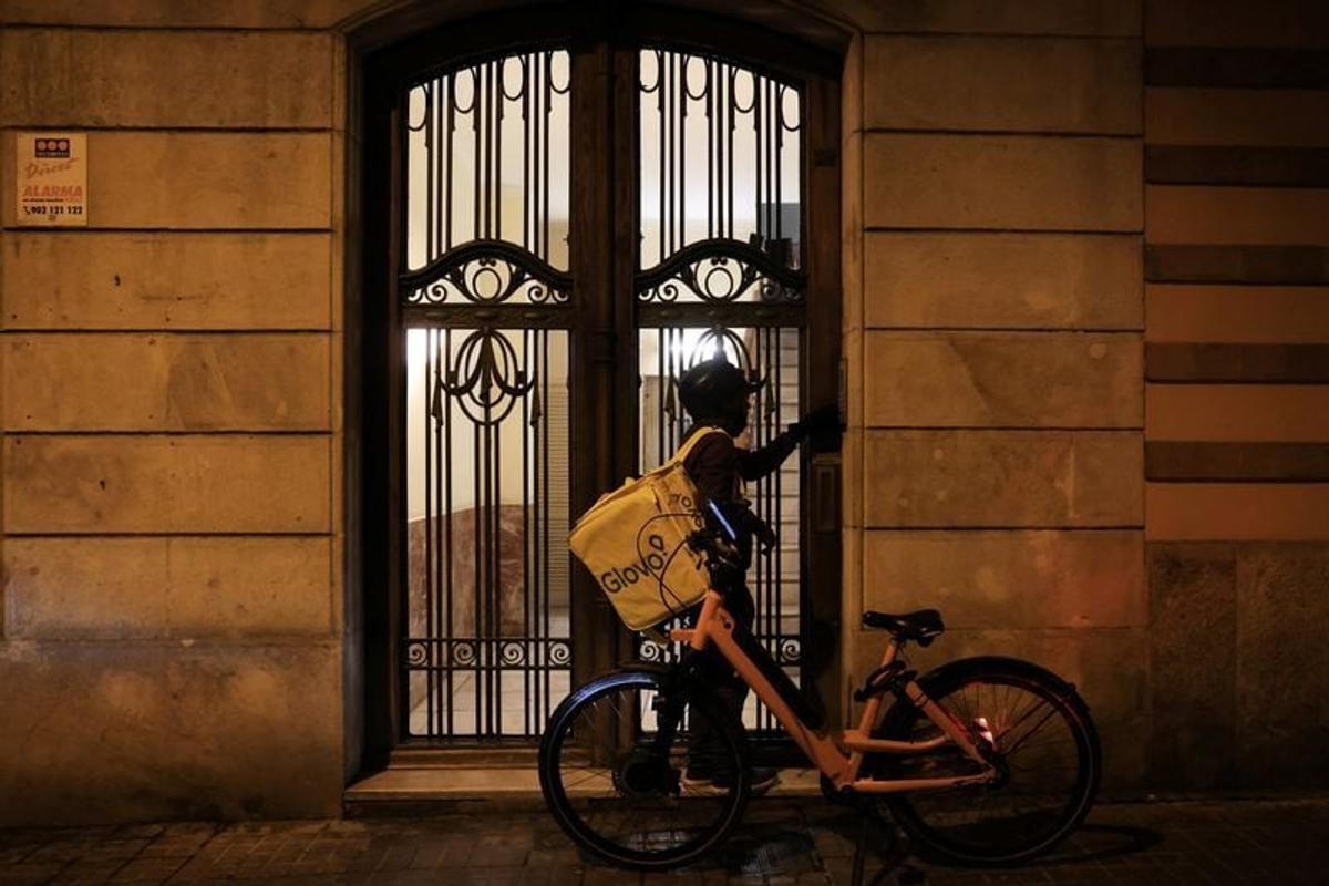 A delivery person rings the doorbell of an apartment to deliver an order to customers, in Barcelona, Spain, March 19, 2025.   (Nacho Doce/Reuters)
