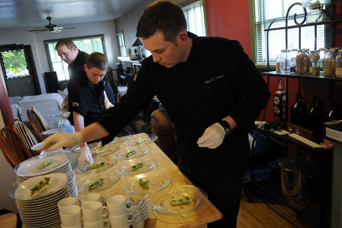 Chef Adam Hegsted and his brothers, Alex Stoy (center) and Ryan Stoy (rear), put cilantro on the avocado-crab cannelloni in the tiny kitchen at Riverfront Farms. 
