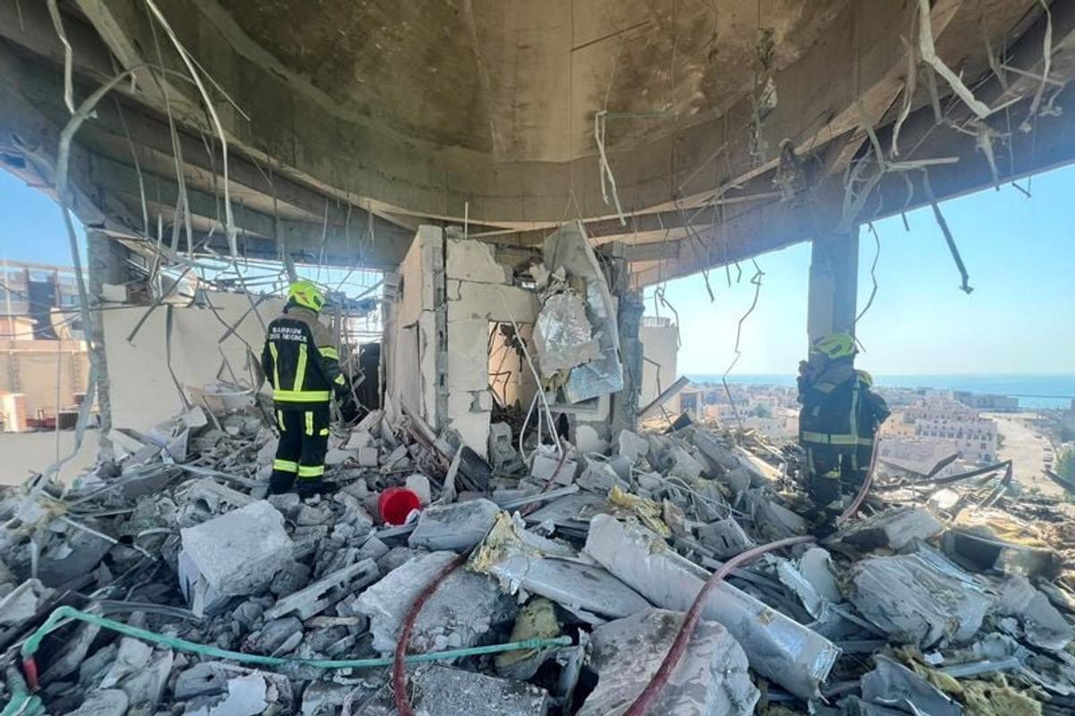 Bahrain civil defense and rescue personnel work in a residential building, which according to the Bahraini Interior Ministry, was hit by an Iranian drone on Saturday, in Muharraq, Bahrain.  (Bahrain Police Media )