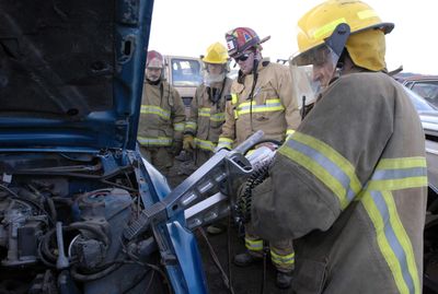 Spokane Valley firefighter David Baird, right, practices removing a fender with an Amkus spreader. Looking on are, left to right, Capt. Terry Gese, firefighter Tom Carleton, and Capt. Ryan Lieuallen. The four took part in vehicle extrication classes Nov. 5.  (Photos by J. BART RAYNIAK / The Spokesman-Review)