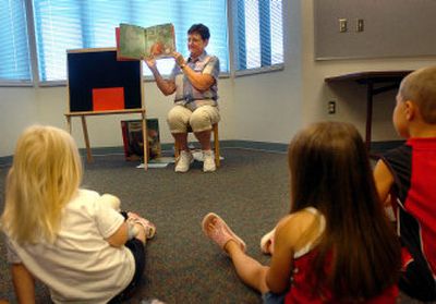 
Lois Penick reads a book Friday at the Indian Trail Library. She is one of eight volunteers conducting story times at the three smaller Spokane library branches. 
 (Photos by AMANDA SMITH / The Spokesman-Review)