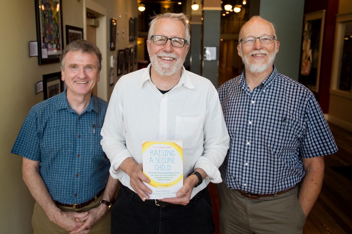From left, Bert Powell, Kent Hoffman and Glen Cooper pose for a photo with the book they co-authored, “Raising a Secure Child,” on  May 10 in Spokane. The trio founded Spokane’s Circle of Security. (Tyler Tjomsland / The Spokesman-Review)