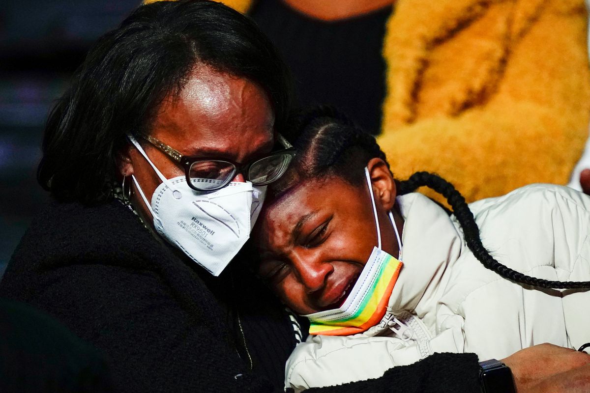 Mourners embrace during funeral services for the victims of a deadly row house fire, at Temple University in Philadelphia, Monday, Jan. 17, 2022. Officials say it