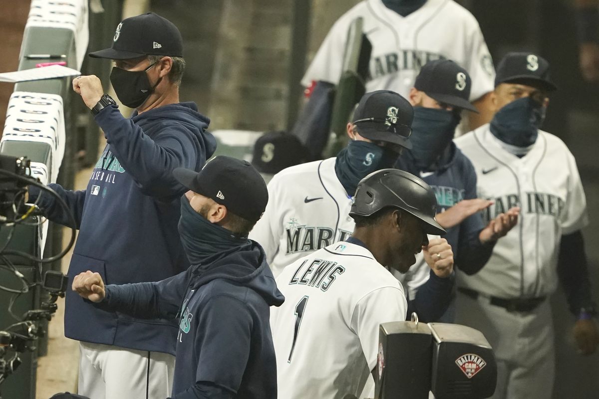 The Seattle Mariners’ Kyle Lewis is greeted in the dugout after he hit a two-run home run during the fifth inning of the first half of a doubleheader in Seattle on Monday.  (Ted S. Warren)