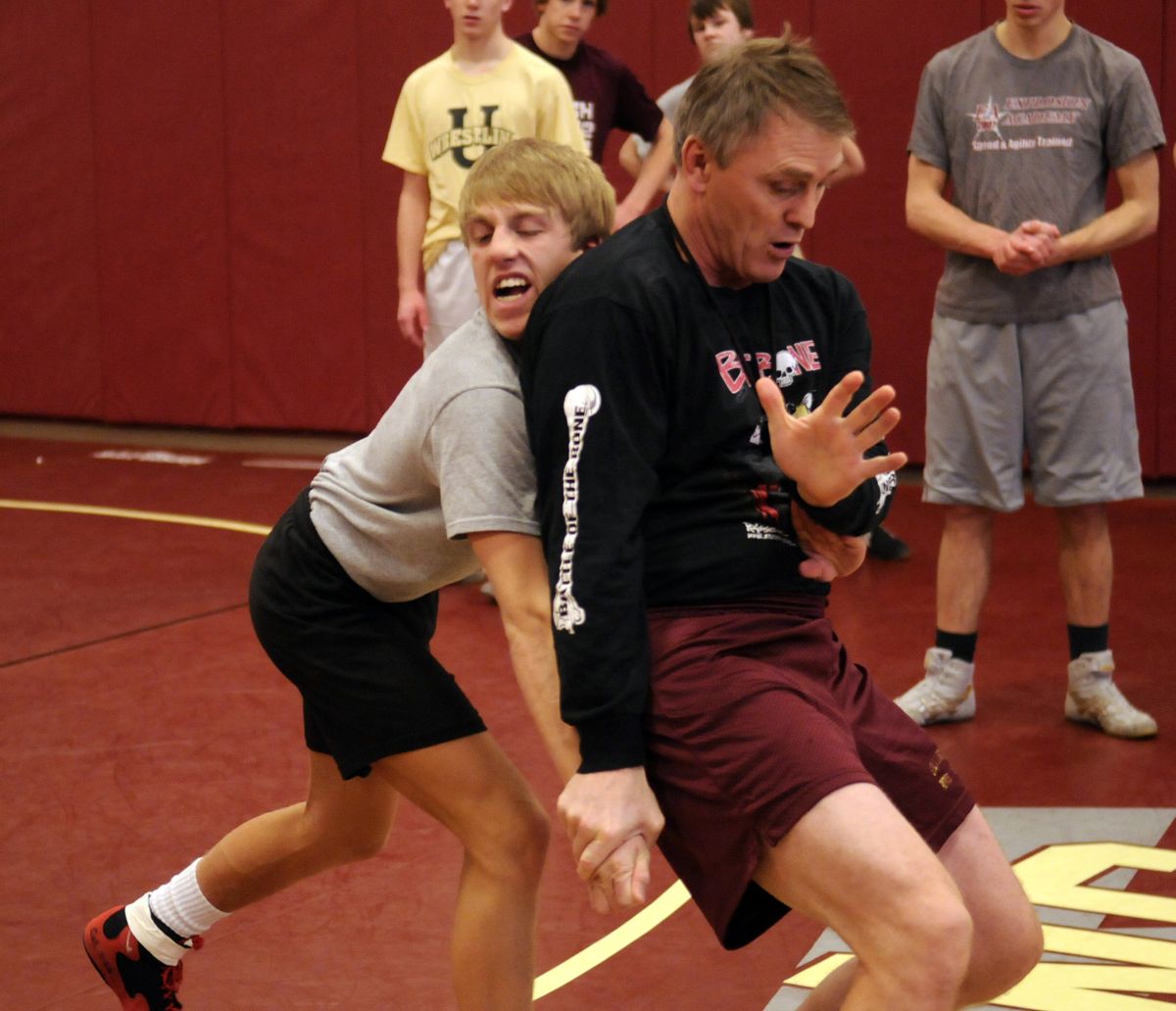 University High School wrestling coach Don Owen, right, demonstrates a “stand-up escape” with senior Brandon Matlock during practice Wednesday. A  two-time state placer, Matlock is one of most admired and respected leaders in the wrestling room.  (J. BART RAYNIAK)