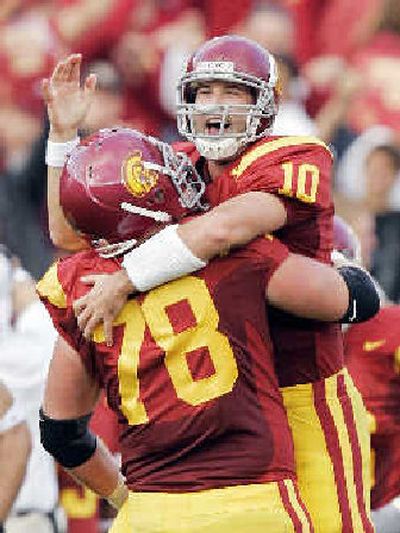 
USC tackle Kyle Williams lifts John David Booty after his first-half touchdown pass Saturday. 
 (Associated Press / The Spokesman-Review)