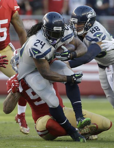 Seattle Seahawks running back Marshawn Lynch, shown here in a game against San Francisco last October, is retiring from the NFL. (Jeff Chiu / Associated Press)