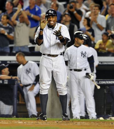 New York Yankees' Curtis Granderson stands at home plate applauding Mark Teixeira for his two-run home run in the first inning against the Seattle Mariners in a baseball game Monday. (Associated Press)