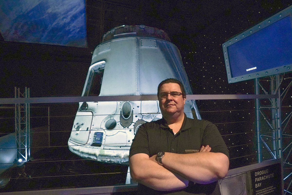 Kyle Hippchen, a Florida-based airline captain, poses for a photo in front of a SpaceX Dragon capsule at the Kennedy Space Center Visitor Complex in Cape Canaveral, Fla., Friday, Jan. 21, 2022. Hippchen, the real winner of a first-of-its-kind sweepstakes, gave his seat on a SpaceX flight to his college roommate. Though his secret is finally out, that doesn’t make it any easier knowing he missed his chance to orbit Earth because he exceeded the weight limit.  (John Raoux)