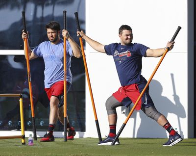 Atlanta Braves catchers Travis D’Arnaud, left, and Shea Langeliers do agility drills to loosen up for baseball spring training Sunday, Feb. 16, 2020, in North Port, Fla. (Curtis Compton / Atlanta Journal-Constitution via AP)