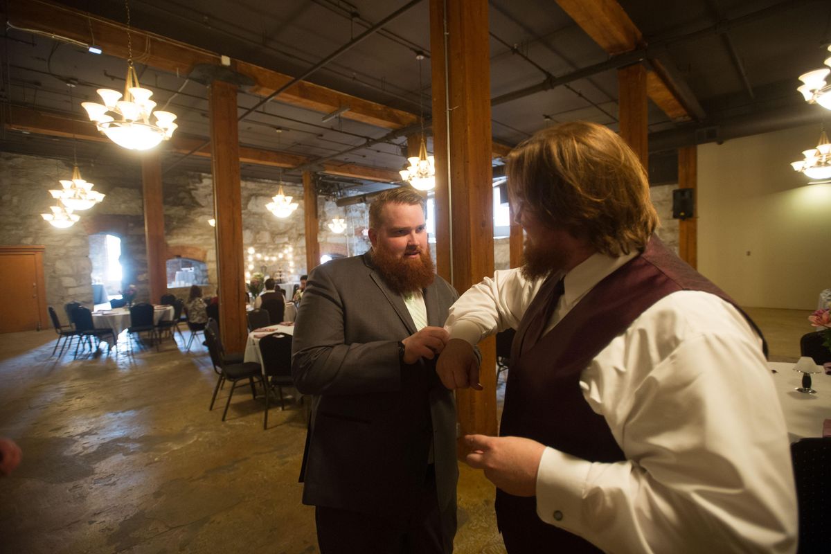 Adam Prybylinski, left, helps his older brother Aaron fine tune his attire before getting married to Melissa Hightower. The two got married during Gonzaga