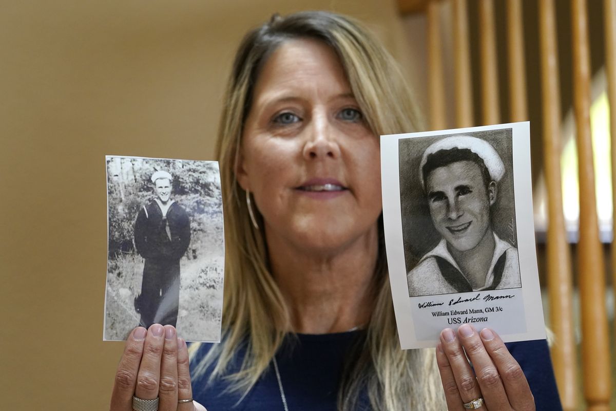 Teri Mann Whyatt displays photos of her uncle, William Edward Mann, who died on the USS Arizona during the bombing of Pearl Harbor, at her home Wednesday, July 14, 2021, in Newcastle, Wash. In recent years, the U.S. military has taken advantage of advances in DNA technology to identify the remains of hundreds of sailors and Marines who died in the 1941 bombing of Pearl Harbor and has sent them home to their families across the country for burial. The remains of 85 unknowns from the USS Arizona, which lost more men during the attack than any other ship, haven