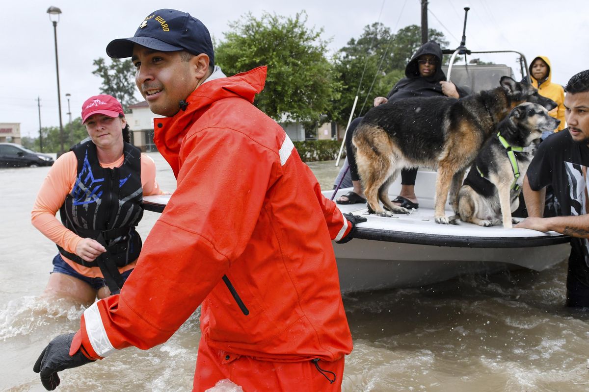 Volunteers and first responders work together to rescue residents from rising flood waters in Houston on Tuesday, Aug. 29, 2017. (Scott Clause / Daily Advertiser via AP)