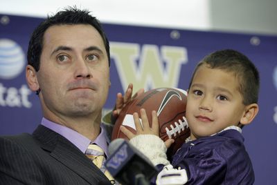 New Washington football coach Steve Sarkisian holds son Brady, 3, at the news conference announcing his hiring Monday. (Associated Press / The Spokesman-Review)