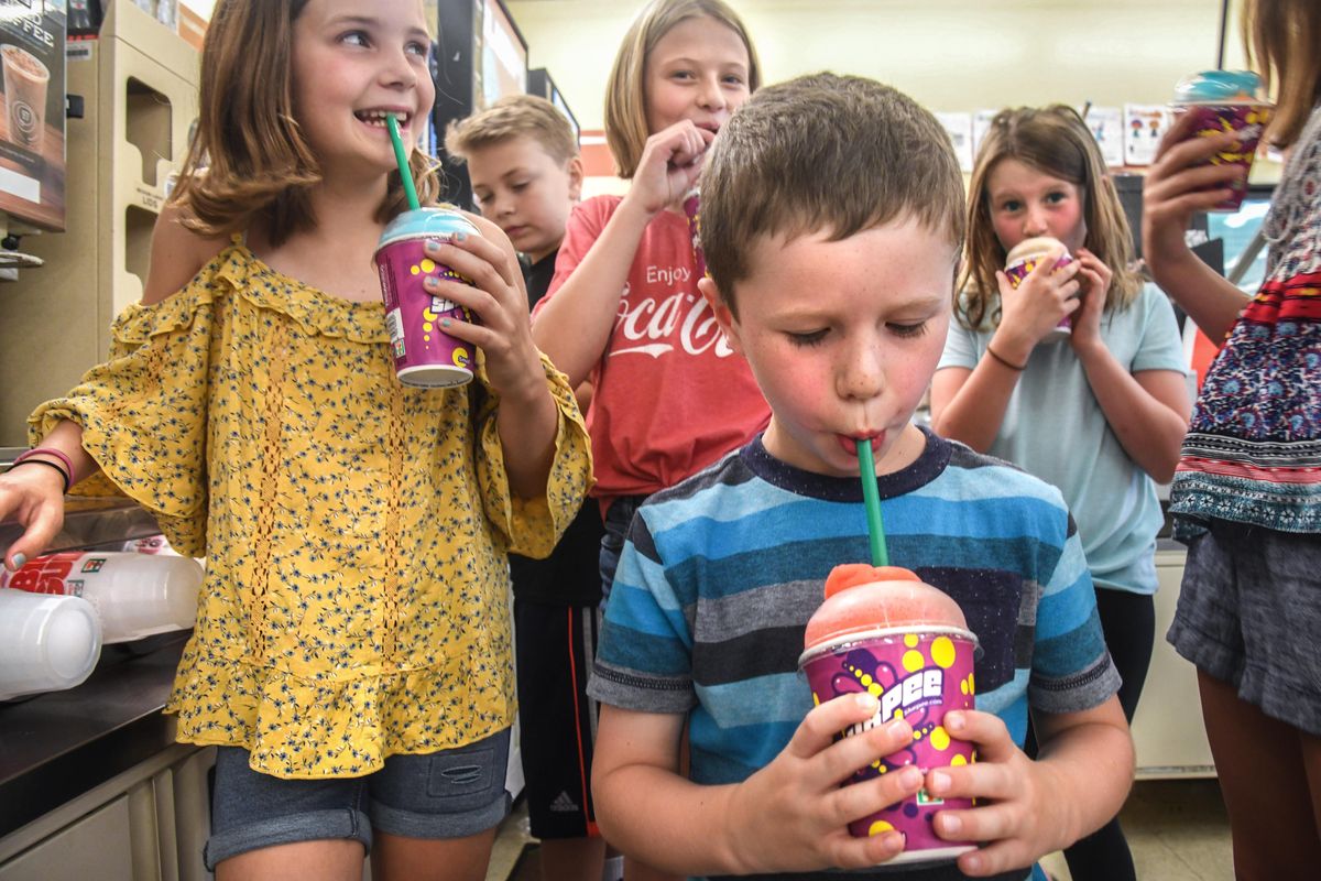 Nolan Traeger, 6, front, enjoys his wild cherry/blue raspberry Slurpee during 7-Eleven Free Slurpee Day, Wednesday, July 11, 2018 at the 13th Avenue and Grand Boulevard store in Spokane, Wash. Behind Nolan, from left, is Dylan Potter, 11, Knox Whaley, 8, Meg Whaley, 10, and Amelia Traeger, 9. (Dan Pelle / The Spokesman-Review)