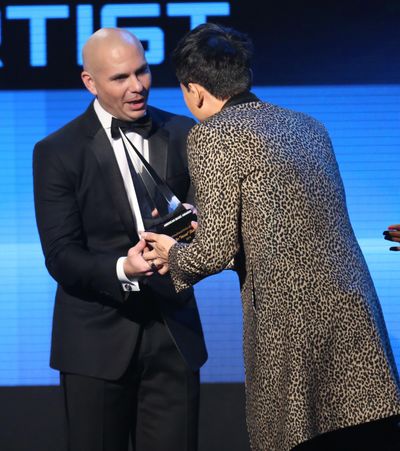 Pitbull, left, presents Zhang Jie with the award for international artist of the year at the 42nd annual American Music Awards at Nokia Theatre L.A. Live on Sunday, Nov. 23, 2014, in Los Angeles. (Matt Sayles / Associated Press)