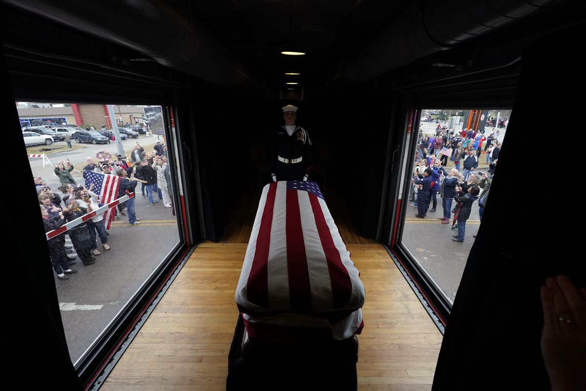 The flag-draped casket of former President George H.W. Bush passes through Magnolia, Texas, on Thursday, Dec. 6, 2018, along the train route from Spring to College Station, Texas. (David J. Phillip / AP)