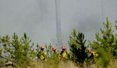 Firefighters worked to secure a fire off Redneck Drive near Blanchard, Idaho, on Wednesday.  (Kathy Plonka / The Spokesman-Review)