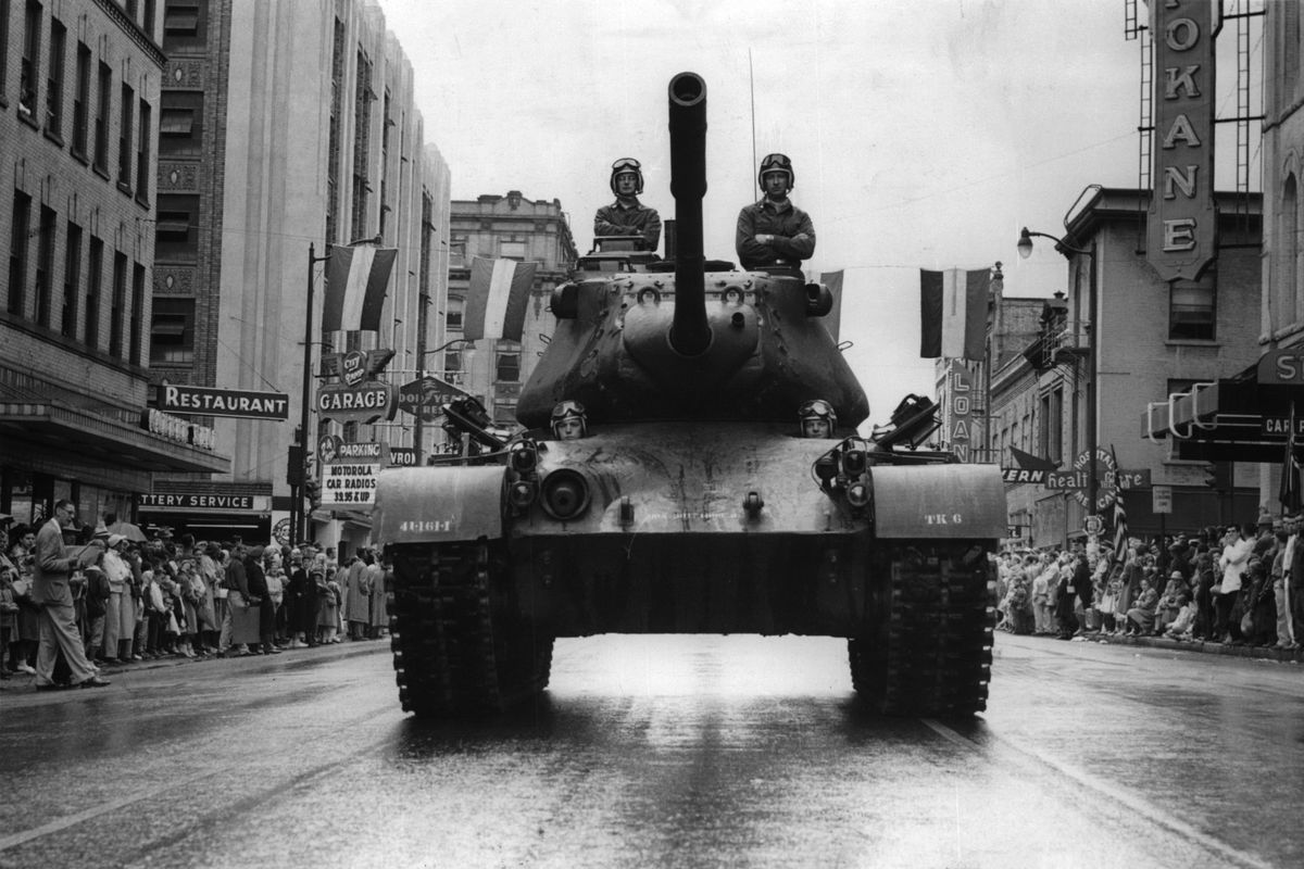 1957: A National Guard tank and its crew pauses for a newspaper photographer at West First Avenue and Stevens Street during the Lilac Festival-Armed Forces Day Parade. The new Armed Forces Day was combined with the Lilac Festival for the first time in 1957. The nation was at the peak of Cold War fear and military spending, though the national economy was strong. The Inland Northwest economy was booming, too, with Kaiser Aluminum, part of the buildup for World War II, employing thousands of Spokane workers in peacetime manufacturing. Yet, an atomic war and the Soviet Union were still on the minds of nearly every American. (Spokesman-Review Photo Archives)
