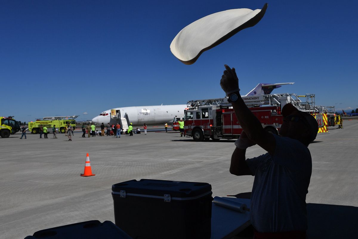 Mark Starr, owner of David’s Pizza, tosses dough as he cooks for first responders and volunteers during a training excercise on Wednesday, Jun 22, 2022, at Spokane International Airport in Airway Heights, Wash.  (Tyler Tjomsland/The Spokesman-Review)