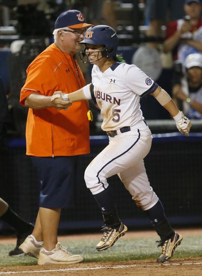 Auburn's Emily Carosone, right, slaps hands with coach Clint Myers after hitting the game-winning home run against Oklahoma in the eighth inning of the second game of the best-of-three championship series. (Sue Ogrocki / Associated Press)
