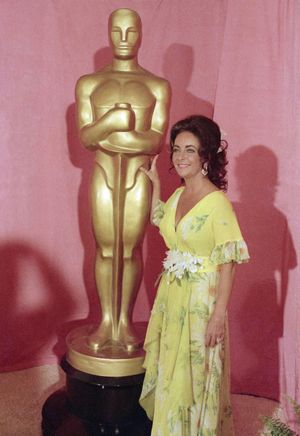 FILE-   This April 2, 1974 file photo shows actress Elizabeth Taylor standing by a statue of the Academy Award Oscar in Los Angeles.  Elizabeth Taylor had it all: the violet, almond-shaped eyes, the creamy skin, the pouty lips and raven hair. Of course, there were her Oscars, iconic roles and many husbands, too, but Taylor is indeed most renowned for her beauty. She died Wednesday at age 79 of congestive heart failure. (Associated Press)