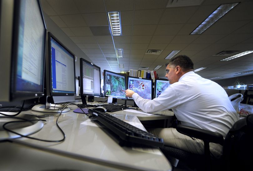 Matt Fugazzi, lead forecaster for the National Weather Service office  in Spokane,  works with a bank of computers Monday. Using data compiled over 30 years to establish a “normal” pattern, the forecasters predict the immediate and-long range weather. (CHRISTOPHER ANDERSON / The Spokesman-Review)