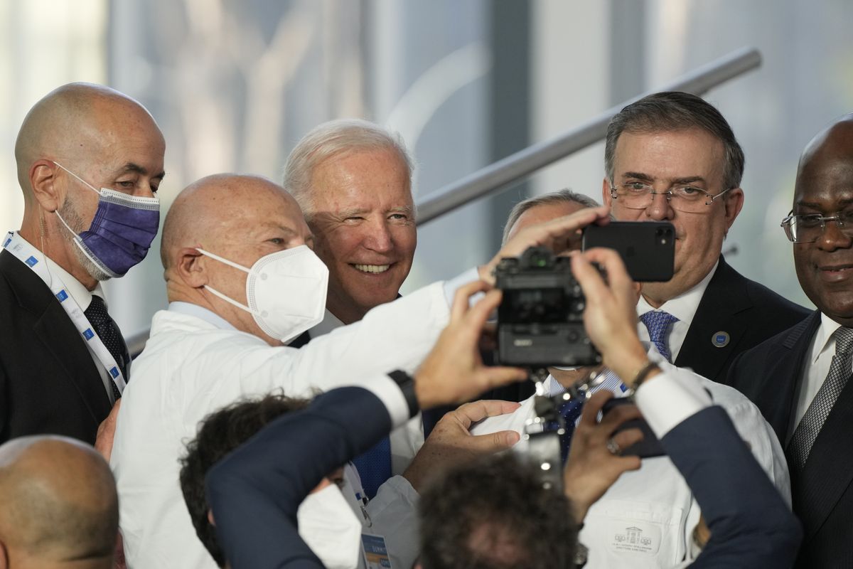 President Joe Biden poses for a selfie with medical personnel and other world leaders during a group photo for the G-20 summit Saturday in Rome.  (Gregorio Borgia)
