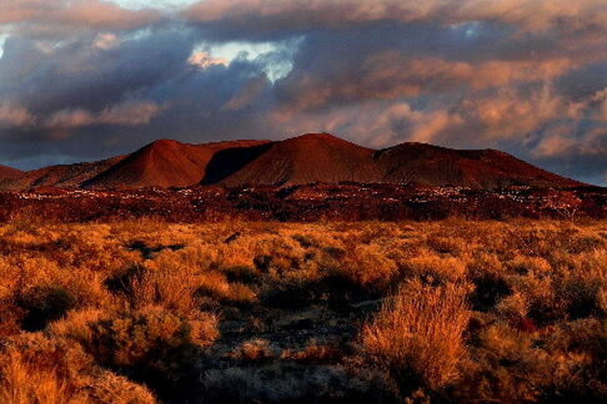 The orange glow of a setting sun colors the Marl Mountains in the central section of the Mojave National Preserve in 2003. The preserve has some of the tallest sand dunes, thickest Joshua tree forests on the continent, as well as lava cones, dry lake beds, basin and range topography.  (Robert Gauthier/Associated Press)