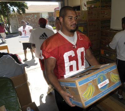 Gabe Jackson, of the EWU football team, carries donated food into the Cheney Food Bank on Friday.  (CHRISTOPHER ANDERSON / The Spokesman-Review)