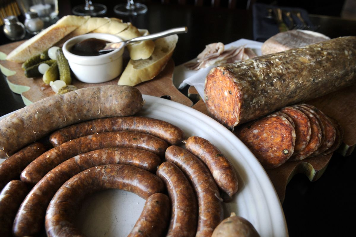 Latah Bistro offerings include duck liver pâté, top left, smoked andouille (the large sausage), lamb sausage (the smaller sausages), and Hungarian salami, right.  (Photos by Dan Pelle / The Spokesman-Review)