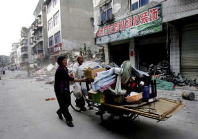 
A man and woman carry possessions retrieved from their collapsed house  in Dujiangyan, in China's  Sichuan province, on Wednesday. Associated Press
 (Associated Press / The Spokesman-Review)