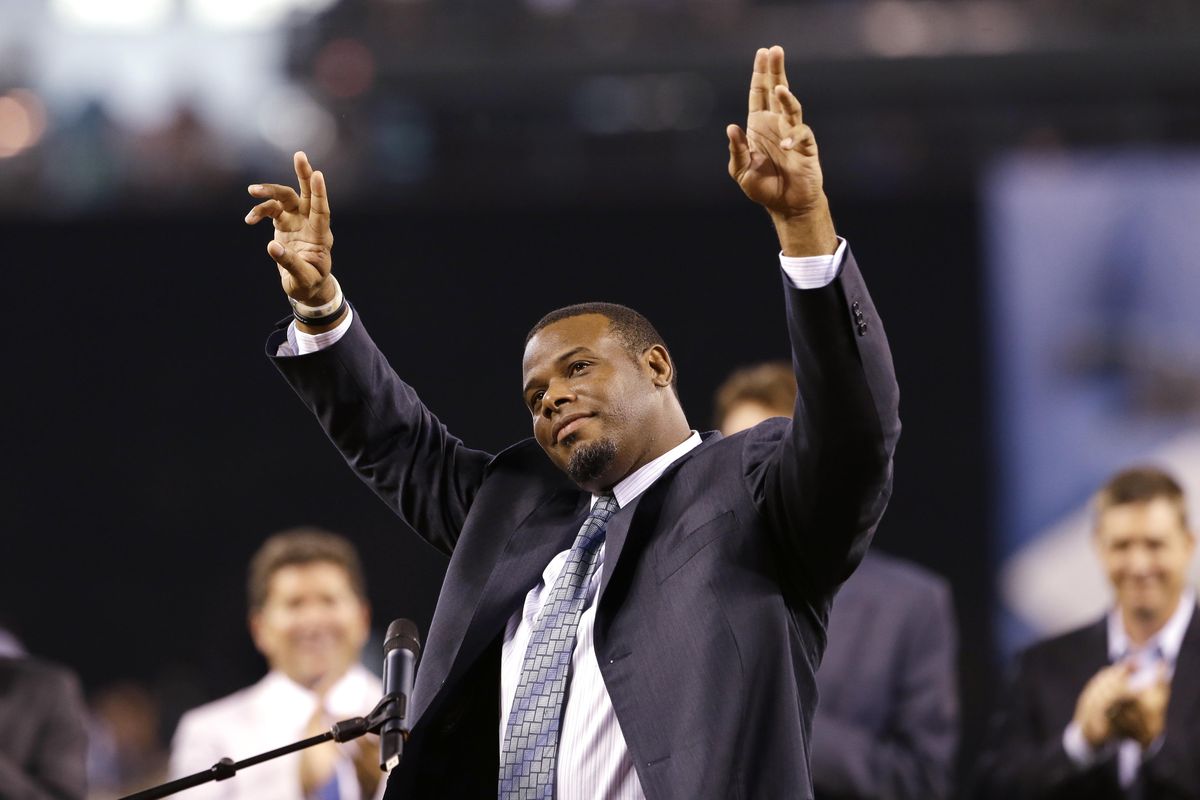 Former Seattle Mariners outfielder Ken Griffey Jr., center, waves to fans as he steps up to speak during a pregame ceremony to induct him into the team