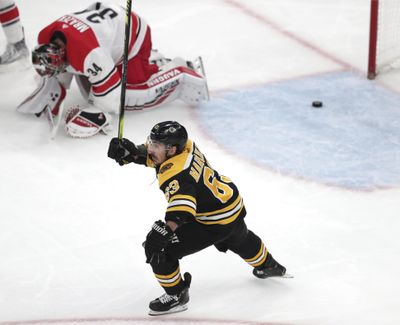 Boston Bruins’ Brad Marchand (63) raises his stick as Carolina Hurricanes goaltender Petr Mrazek (34), of the Czech Republic, drops to the ice after a goal by Patrice Bergeron during the third period in Game 1 of the NHL hockey Stanley Cup Eastern Conference finals Thursday, May 9, 2019, in Boston. (Charles Krupa / Associated Press)