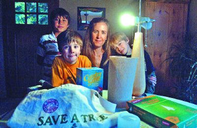Tammy Powell, center, of Sandpoint, uses energy-saving products, including reusable cloth grocery bags and compact fluorescent light bulbs. With her are, from left, Selkirk Petersen, 9, who's a neighborhood friend of her sons Brennan, 7, and Sam, 9.
(Jesse Tinsley / The Spokesman-Review)