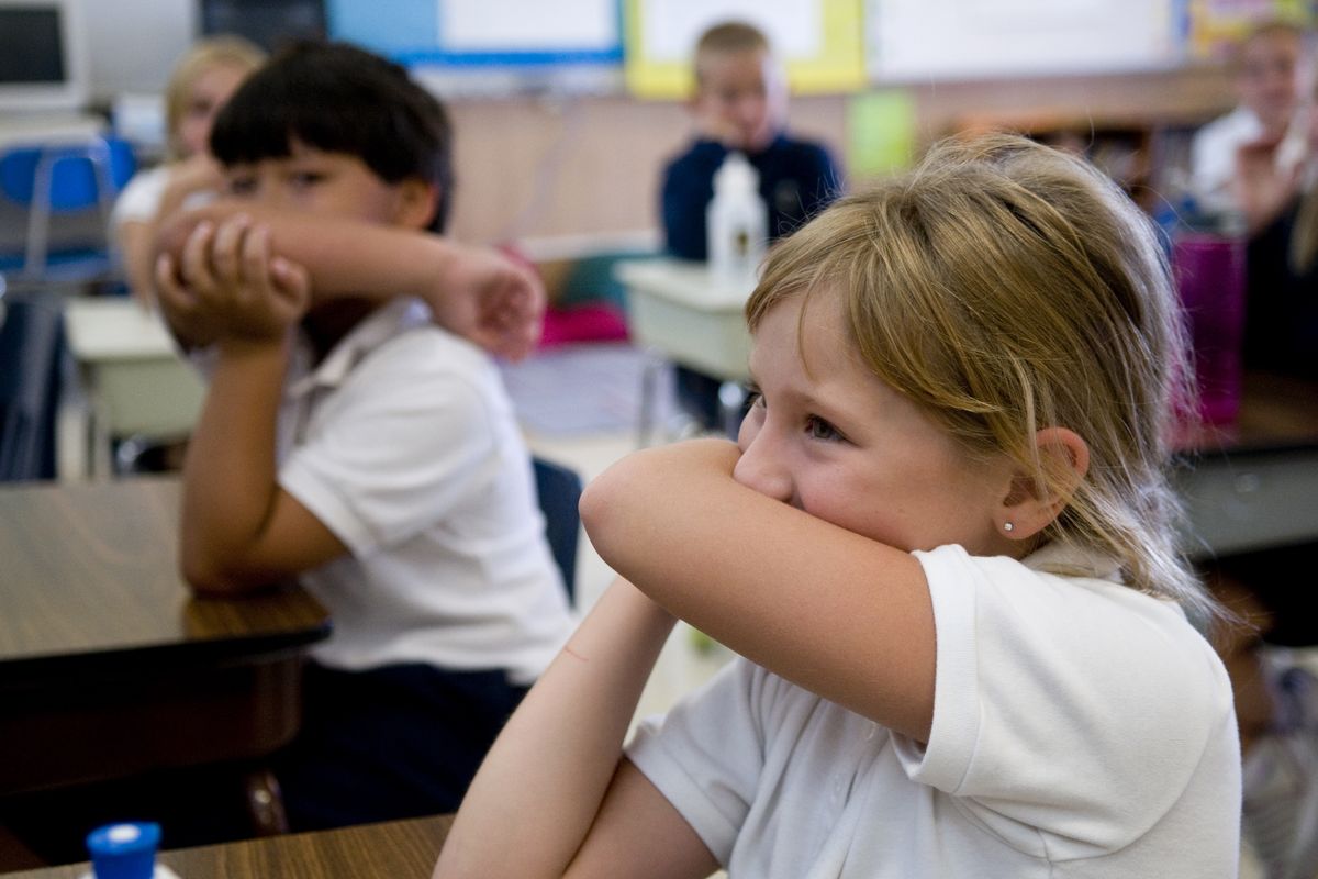 St. Charles School third-grader Amanda Migala practices sleeve-cough etiquette, the most efficient way to prevent the spread of airborne germs. (Colin Mulvany / The Spokesman-Review)