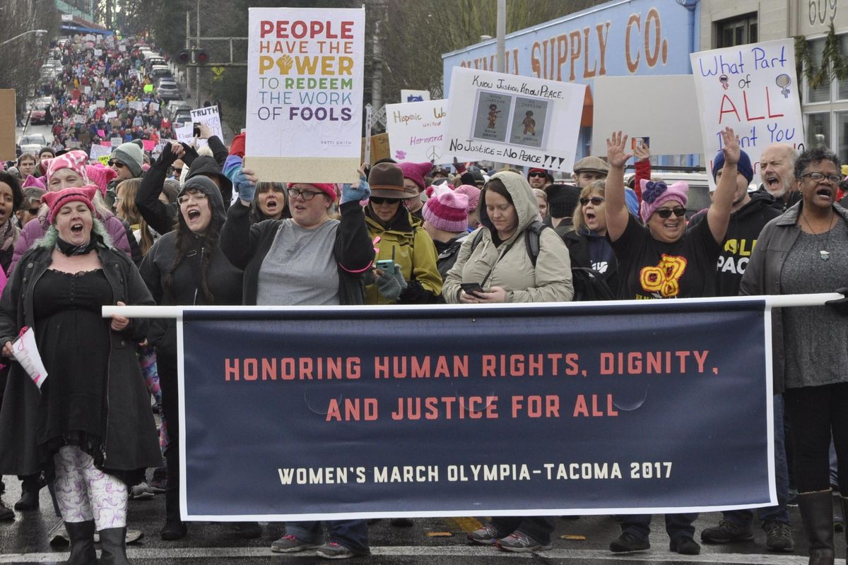 With thousands of protesters behind them, lead demonstrators in the Women’s March pause before making the turn to head back to the state Capitol on Saturday, Jan. 21, 2017. (Jim Camden / The Spokesman-Review)