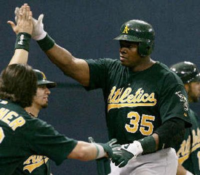 
Oakland players greet Frank Thomas in the ninth after his second home run. 
 (Associated Press / The Spokesman-Review)