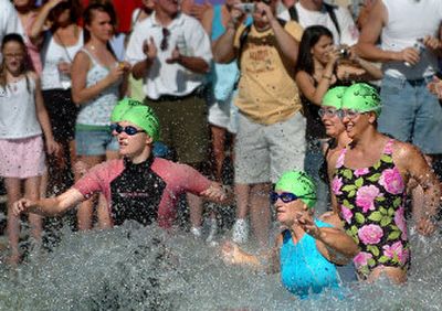 
Swimmers from the second wave of the Valley Girl Triathlon splash into Liberty Lake as friends and family look on Sunday. 
 (Photos by Joe Barrentine / The Spokesman-Review)
