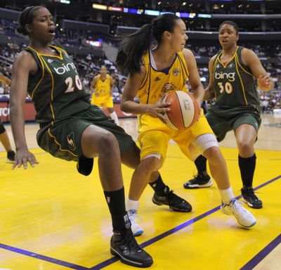 Storm forward Camille Little, left, falls and draws a charge from Sparks guard Kristi Toliver as Tanisha Wright, right, looks on.  (Associated Press)