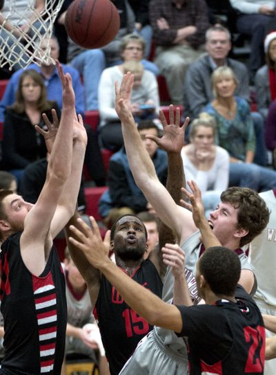Whitworth's Adam Wilks, center, forces his way into the paint and forces up a shot against James Feocco, Jordan Jean, Shakeel Simmons and EZ Garcia of Wells College Monday, Dec. 22, 2014 at Whitworth University.  The visitors from the small New York college were defeated by the Pirates of Whitworth 84-43. (Jesse Tinsley / The Spokesman-Review)