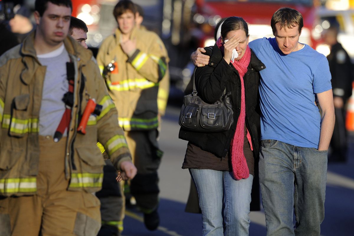 A victim’s family leaves a firehouse staging area following the shootings at Sandy Hook Elementary in Newtown, Conn., where a gunman killed 27 people including himself. (Associated Press)