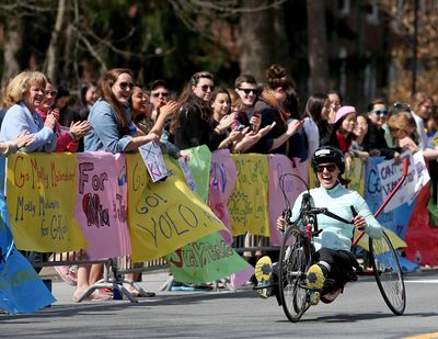 Jessica Kensky, of Medford, Mass., who lost a leg in last year’s bombings, smiles as she rolls through the scream tunnel at Wellesley College during the 118th Boston Marathon Monday in Wellesley, Mass. Kensky caught up to her husband, Patrick Downes, who also lost a leg, to finish together. (Associated Press)
