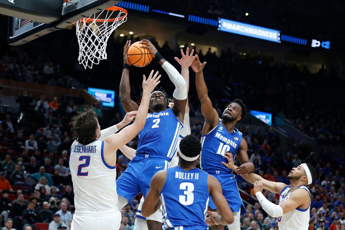 Memphis center Jalen Duren, center, grabs a rebound above Boise State forward Tyson Degenhart, left, as Memphis guard Alex Lomax (10) leaps to assist during the first half of a first round NCAA college basketball tournament game, Thursday, March 17, 2022, in Portland, Ore. (Craig Mitchelldyer)