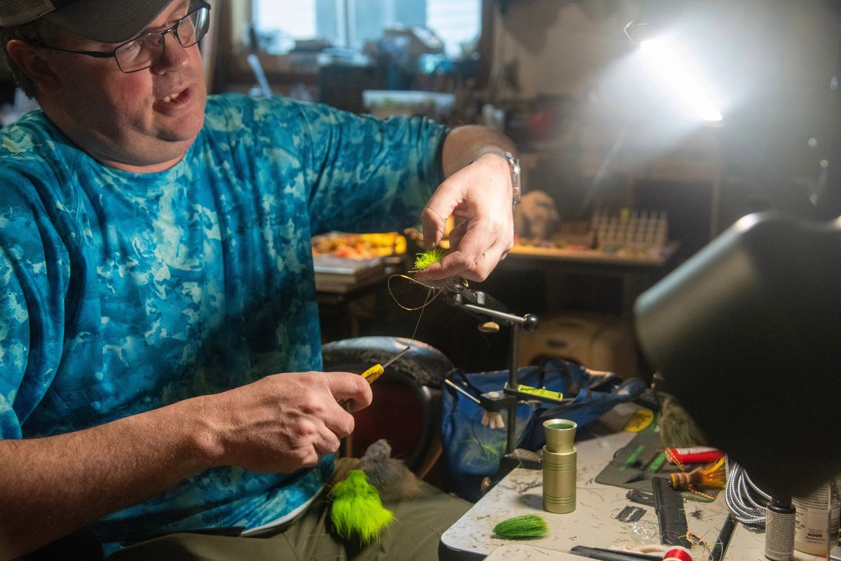 Derek Darst, owner of Saint Maries Flies, is a custom flytier who creates elaborate and colorful deer hair bass flies.  (Michael Wright/The Spokesman-Review )