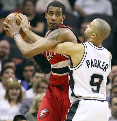 Trail Blazers’ LaMarcus Aldridge looks for room around San Antonio Spurs’ Tony Parker during second half of Wednesday night’s game.  (Associated Press / The Spokesman-Review)
