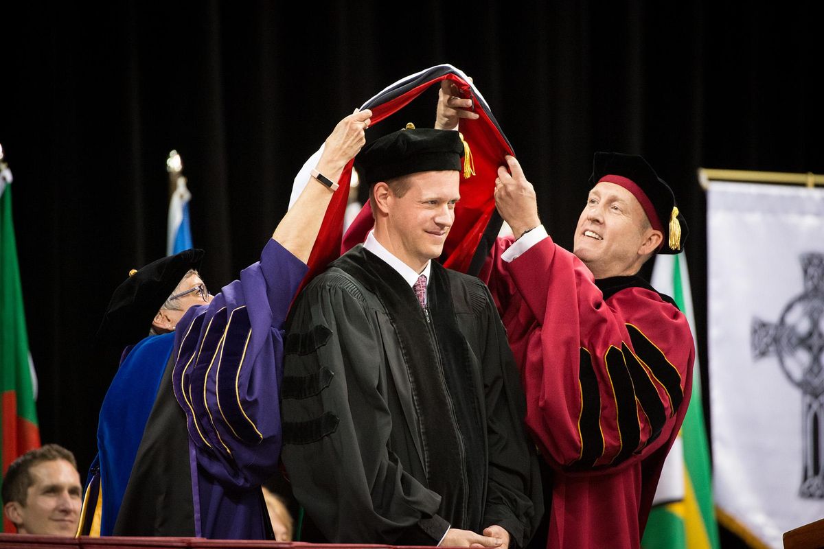 Dr. Timothy Herron is presented with an honorary Doctorate of Humane Letters by Provost and Executive Vice President Caroline Simon and President Beck Taylor at the Whitworth University commencement ceremony on May 19, 2019 at the Spokane Arena. 628 seniors graduated at the university's 129th undergraduate commencement. (Libby Kamrowski / The Spokesman-Review)