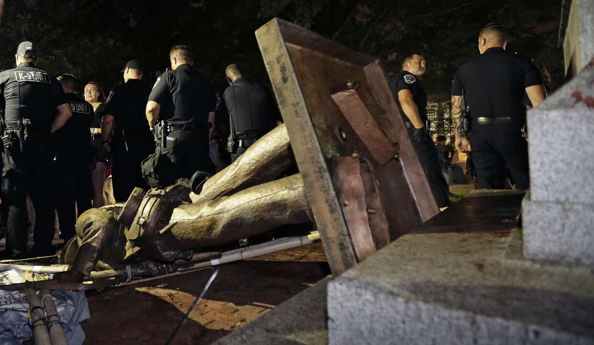 Police stand guard after the confederate statue known as Silent Sam was toppled by protesters on campus at the University of North Carolina in Chapel Hill, N.C., on Monday, Aug. 20, 2018. (Gerry Broome / AP)