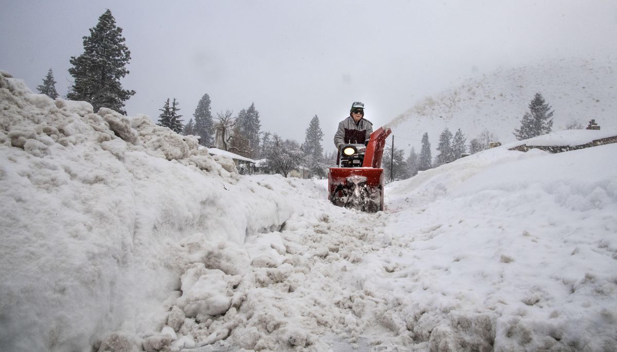 Bill Hackett, 79, plows his way through snow berms to clear his neighbors sidewalks on 37th Avenue near Ivory Street, Tuesday morning, Jan. 10, 2017, in Spokane, Wash. Resident are digging out from a snow storm. (Dan Pelle / The Spokesman-Review)