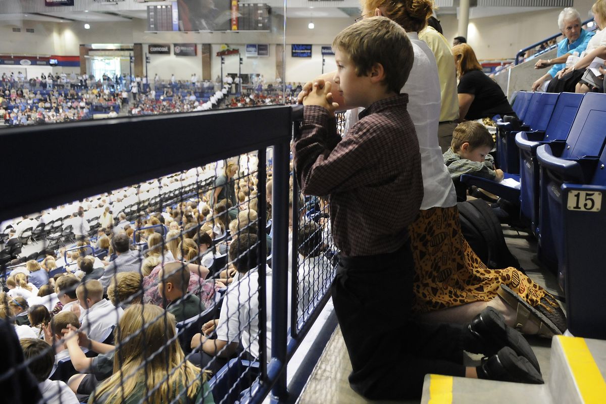 Timothy DeGoede, 8, and his mother Carolyn kneel during Communion at the Mass of installation. 